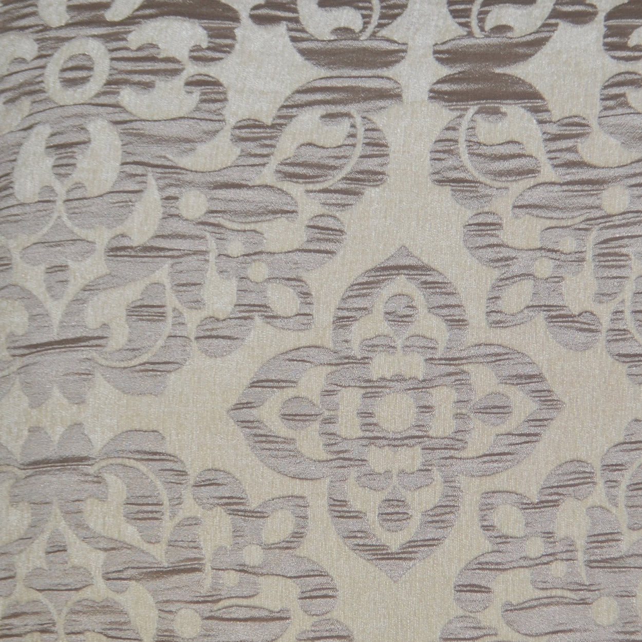 Beige woven fabric with muted gray-lavender damask pattern and ornate floral motif; upholstery or drapery textile.