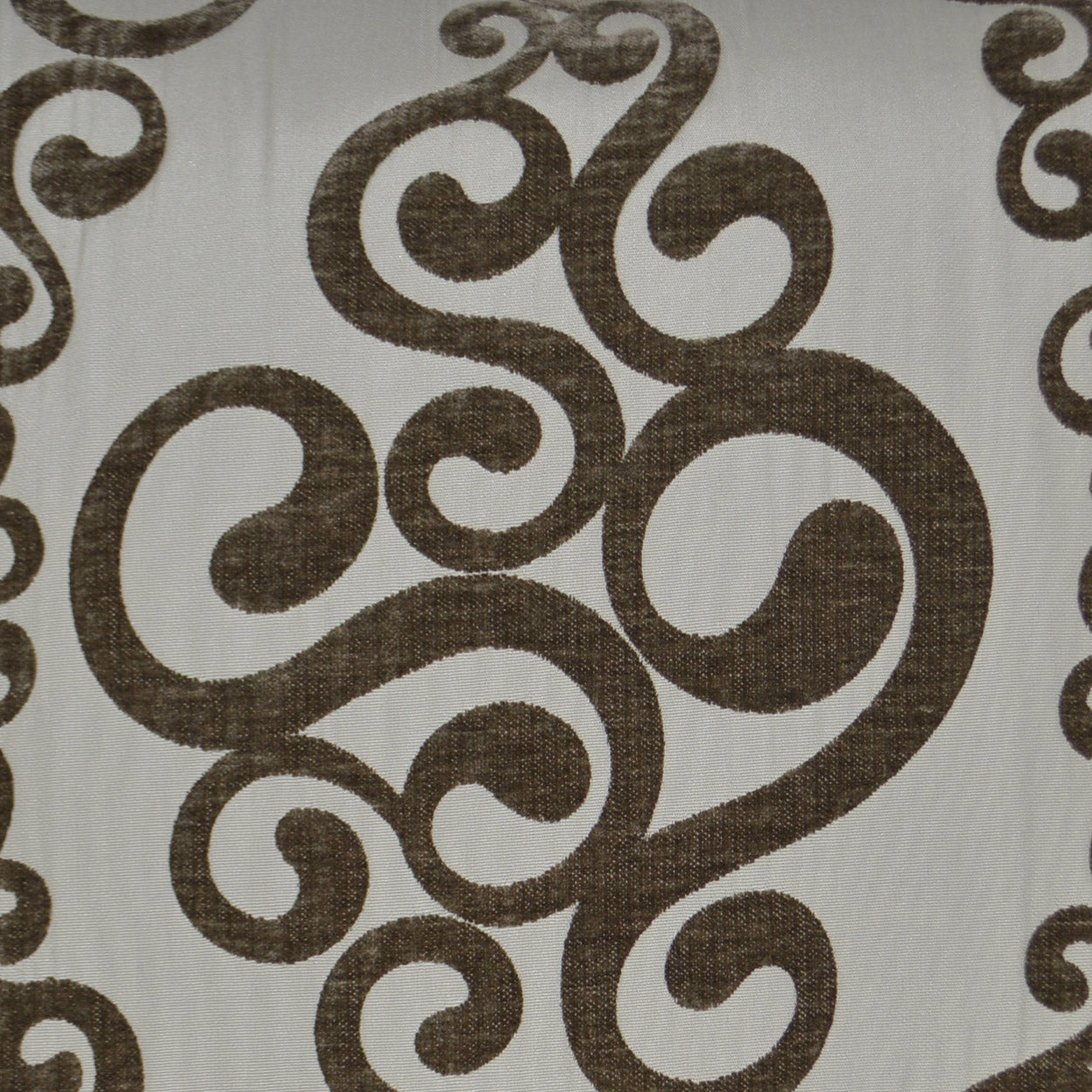 Brown scrolling swirl pattern on cream fabric; textured textile for upholstery or curtains.
