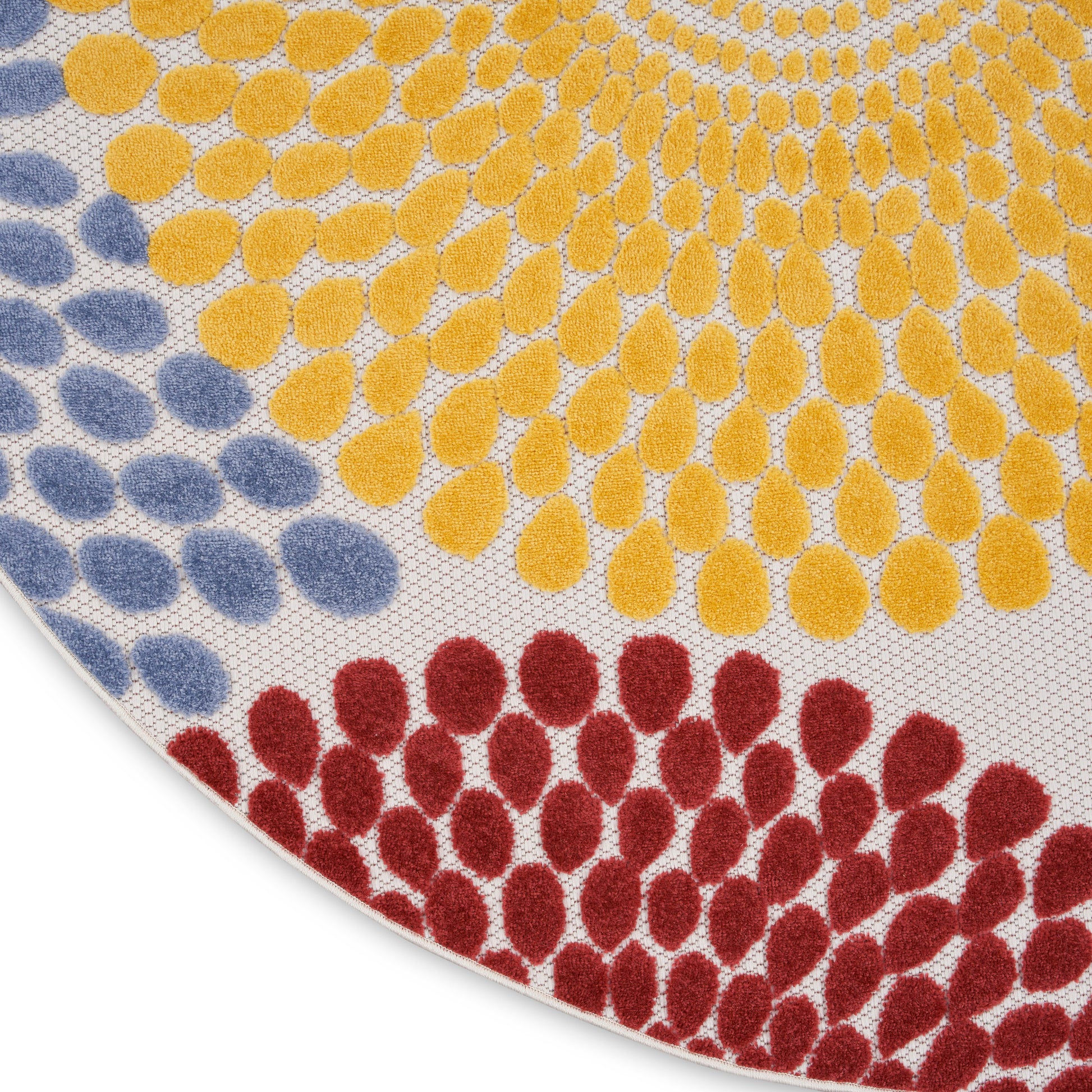 Round rug featuring a multicolor dotted petal pattern: blue, yellow and red oval clusters.