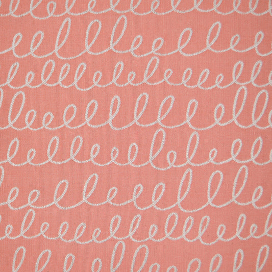 Coral pink fabric with white looping squiggle print in horizontal rows; soft textile texture.