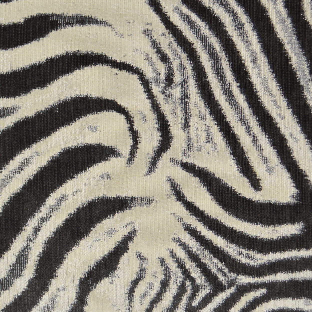 Close-up of zebra-print fabric in black & cream, woven texture with bold wavy stripes.