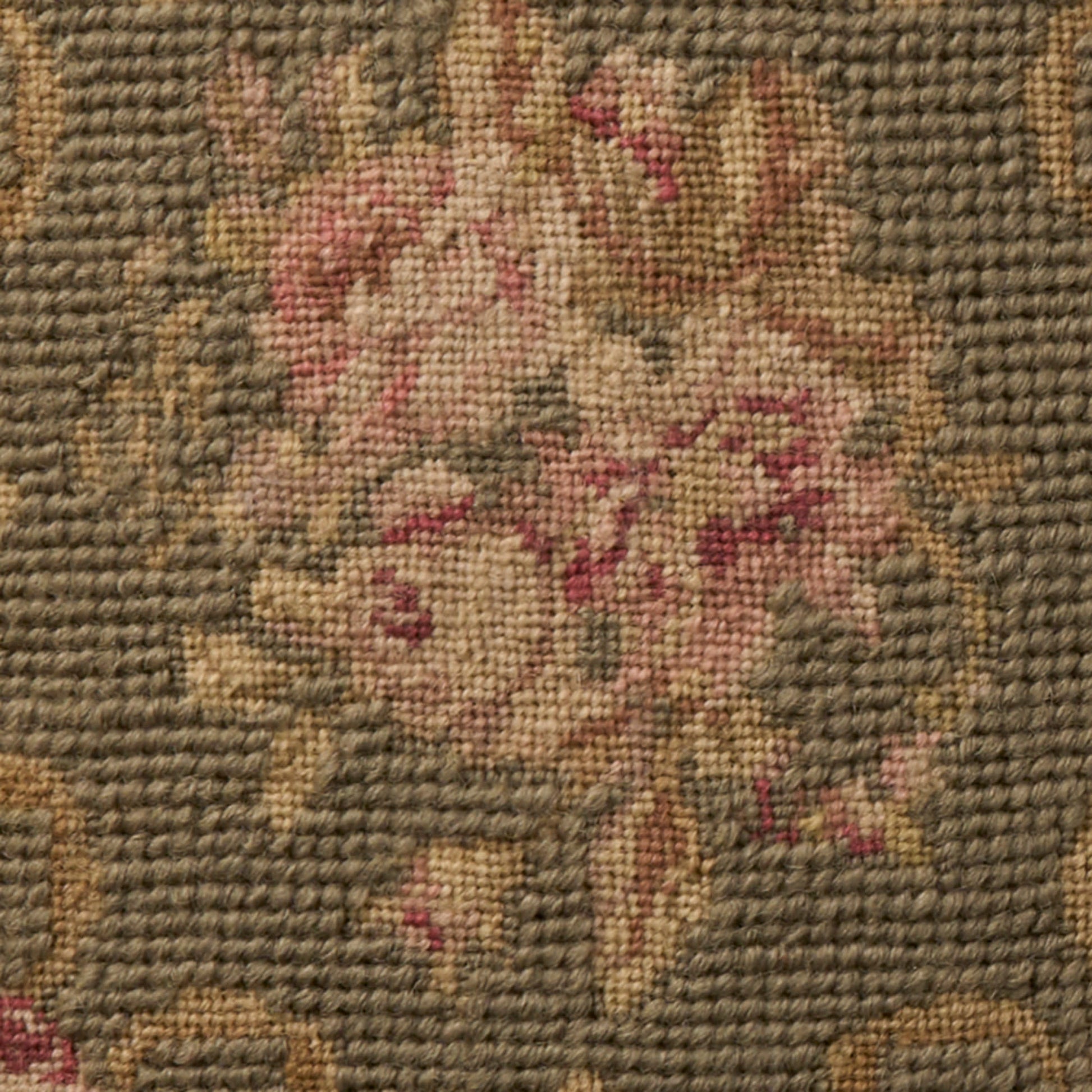 Woven rug with a floral bouquet in pink and beige on a sage background; textured pile, vintage style.