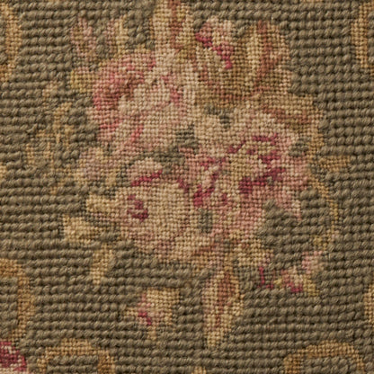 Woven rug with a floral bouquet in pink and beige on a sage background; textured pile, vintage style.