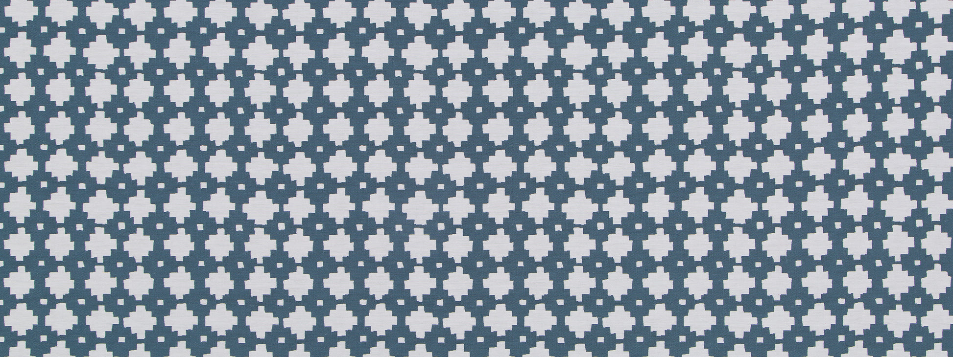 Navy tile with repeating light-blue flower-like quatrefoil motifs in a grid pattern.