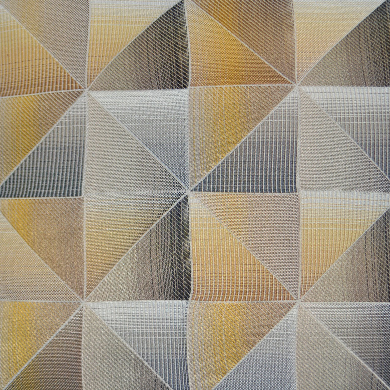 Geometric fabric pattern of interlocking triangles in yellow, gold, taupe and gray with a textured weave.