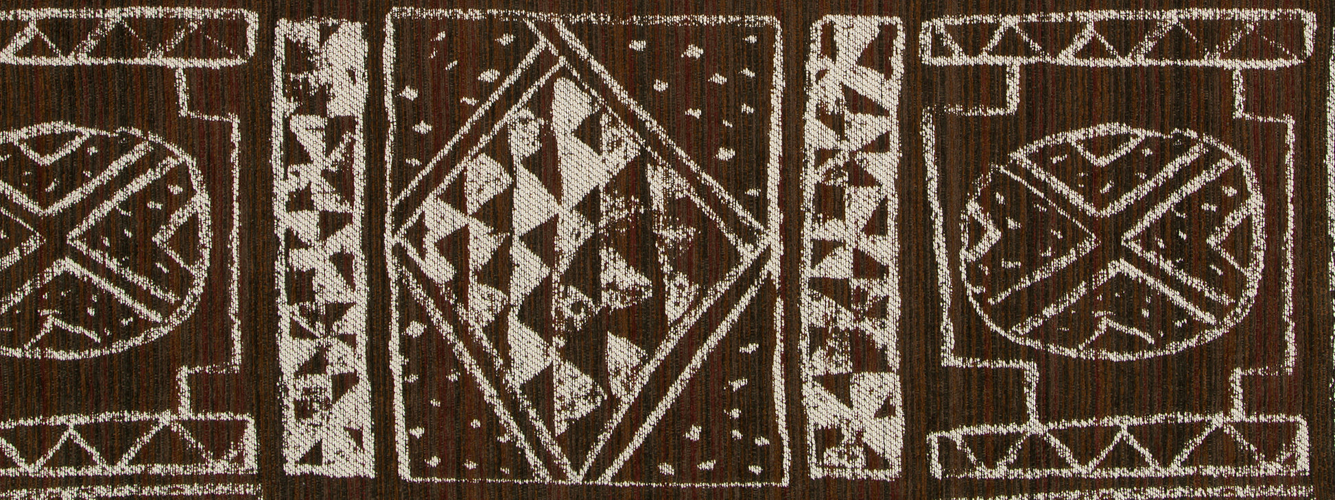 Brown woven upholstery fabric with white geometric tribal motifs featuring diamonds and triangles, textured textile decor.