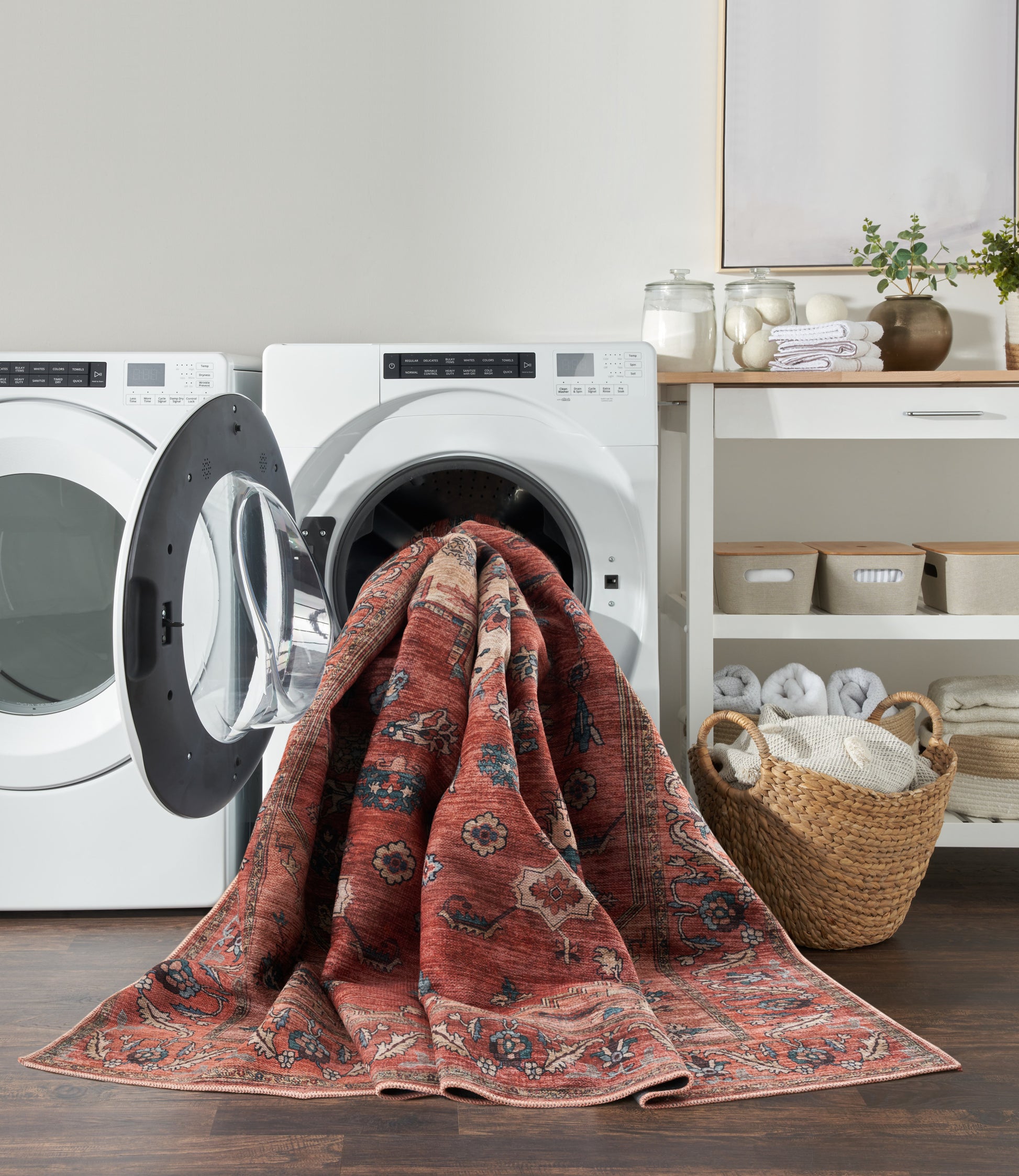 Rust-red oriental-pattern rug draped over a front-load washing machine in a modern laundry room.