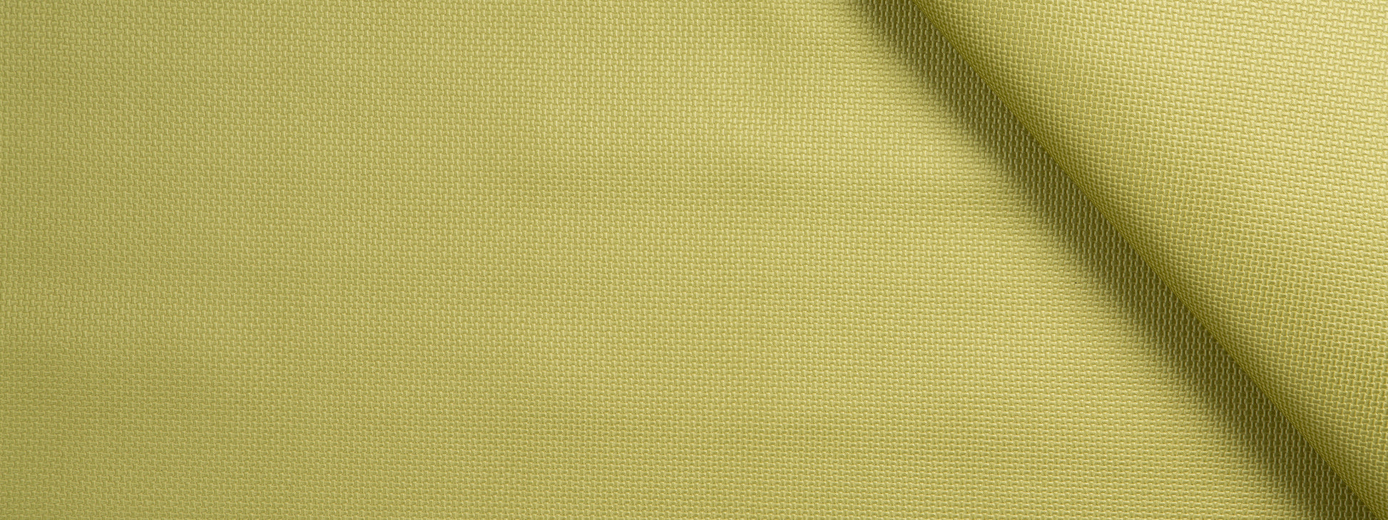 Close-up of light lime-yellow woven fabric with a diagonal fold and soft textured surface.
