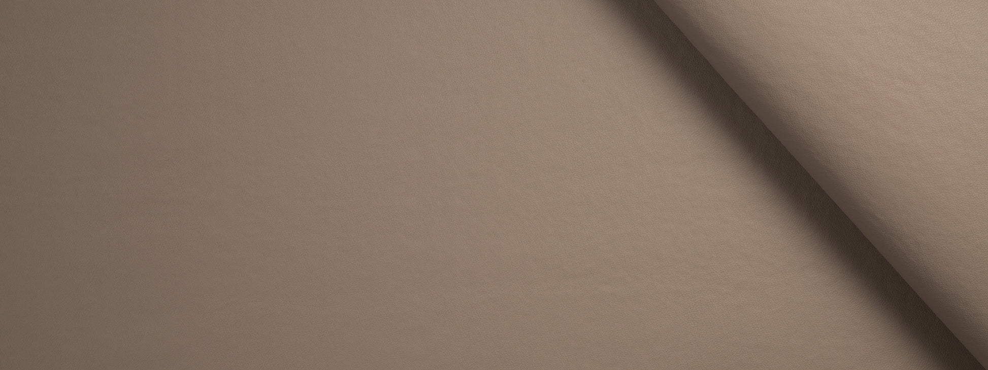 Beige fabric roll with soft texture and curved edge; warm taupe color for upholstery or crafts.