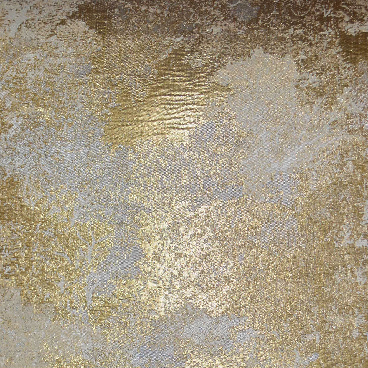 Gold metallic foil texture on gray fabric with irregular shimmer; luxe upholstery or decor.