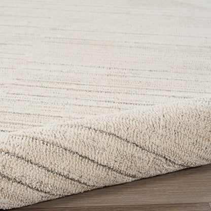 Beige textured rug with loop pile and subtle diagonal stripes along edge on wood floor.