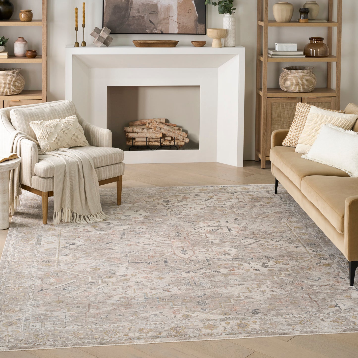 Neutral living room with white angular fireplace, beige sofa, striped chair, light wood shelving, & patterned rug.