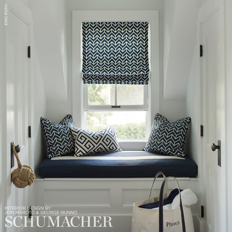 White built-in window seat with navy cushion and navy-white chevron pillows; matching chevron roman shade.