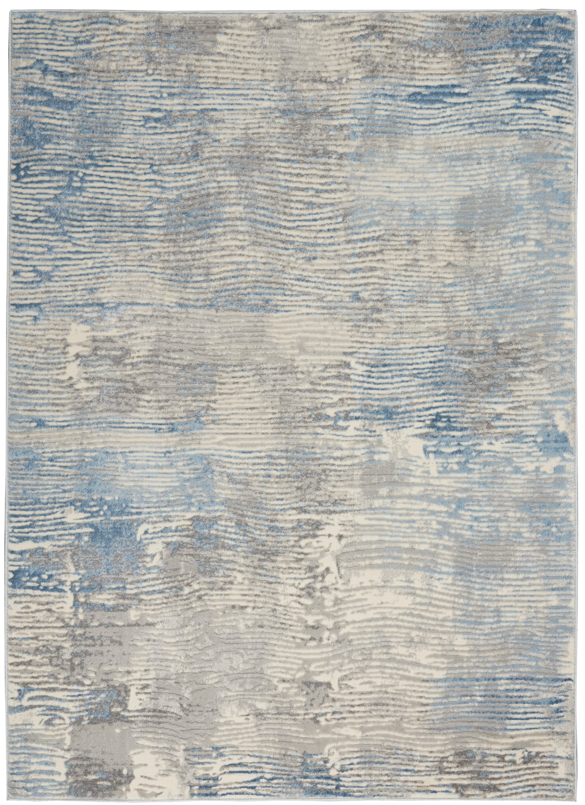 Rectangular abstract rug in blue, gray and beige tones with a distressed, wavy pattern and soft textured pile.
