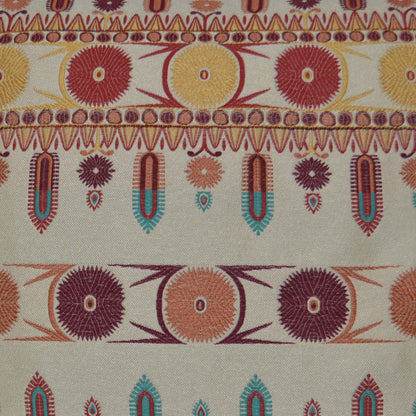 Vibrant woven pillow with sunburst circle motifs and teardrop borders in red, yellow, orange, teal on beige.
