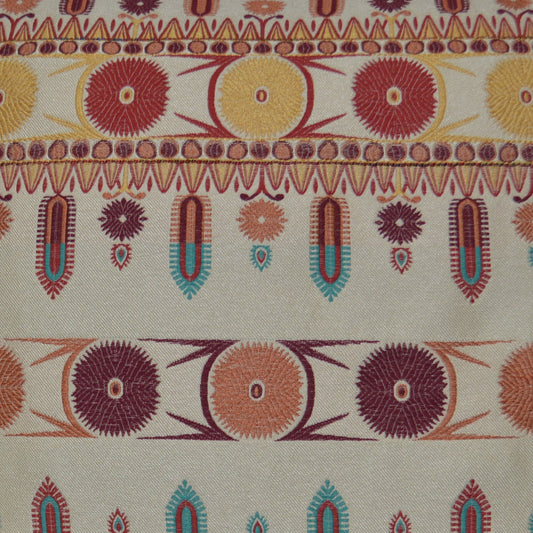 Embroidered textile featuring sunburst circles and geometric borders in orange, yellow, red, teal on beige background