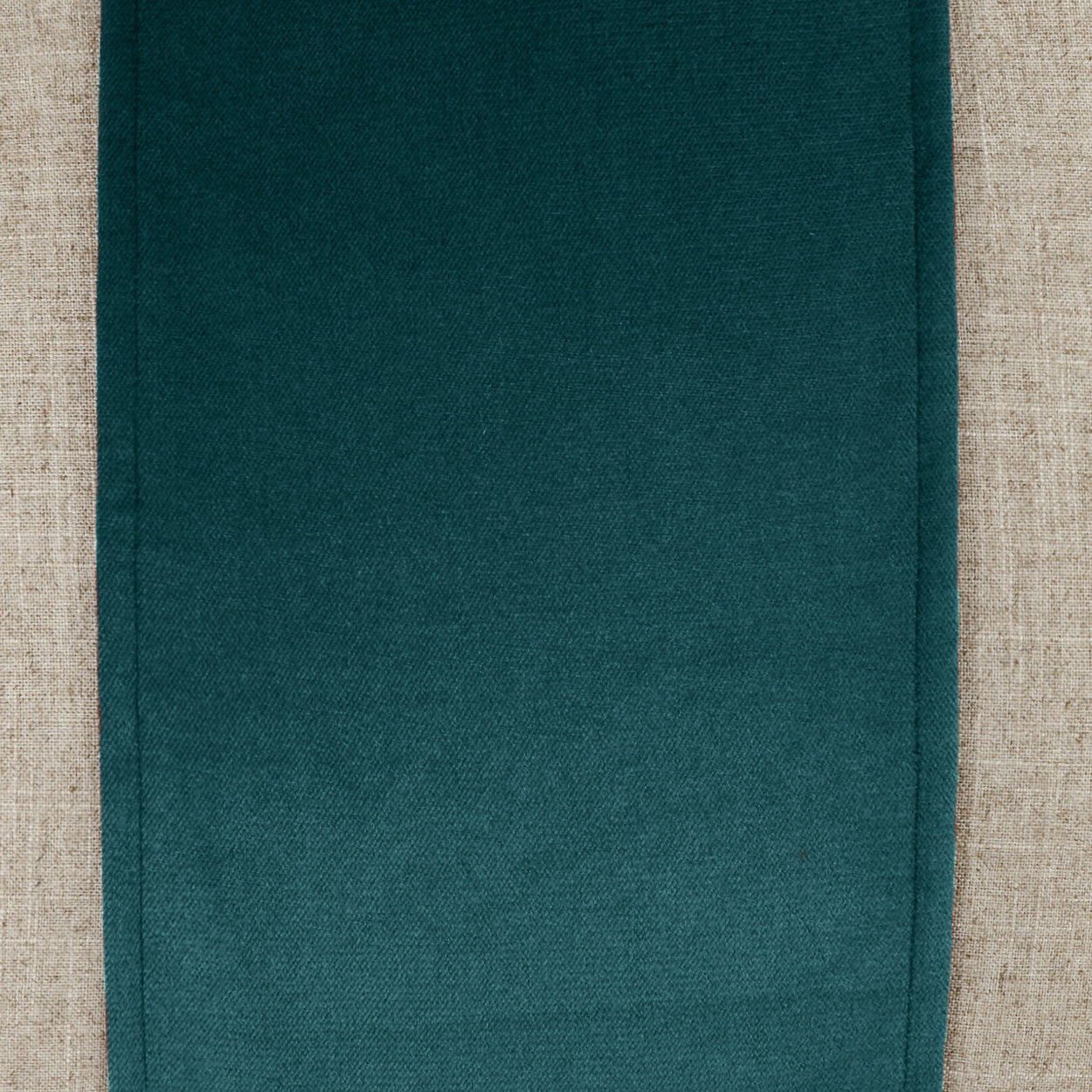 Deep teal woven fabric pillow with a textured surface; 24" x 24" square.