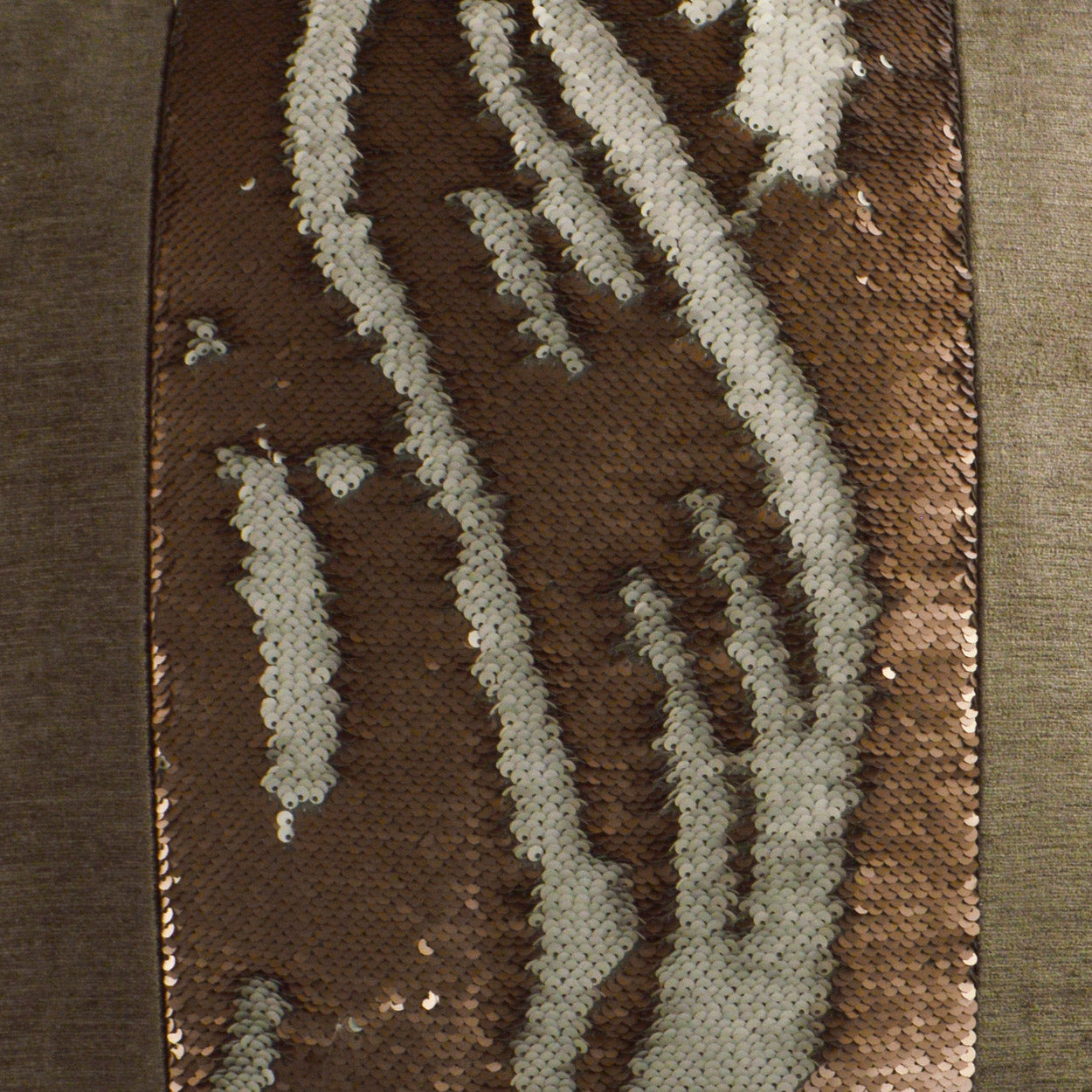 Brown sequined fabric with white curved squiggles; metallic shimmer, close-up of upholstery/fashion textile.