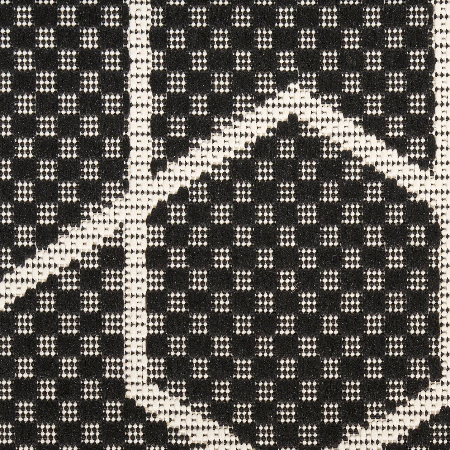 Close-up of black and white woven rug with tiny square motifs forming a geometric diamond pattern (6' x 9').