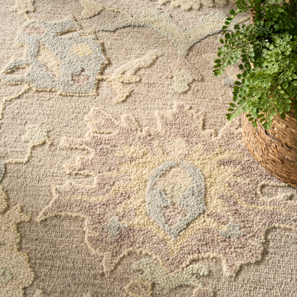 Pastel oriental floor rug with central medallion in pink, beige, blue; woven texture and a plant in a wicker basket nearby.
