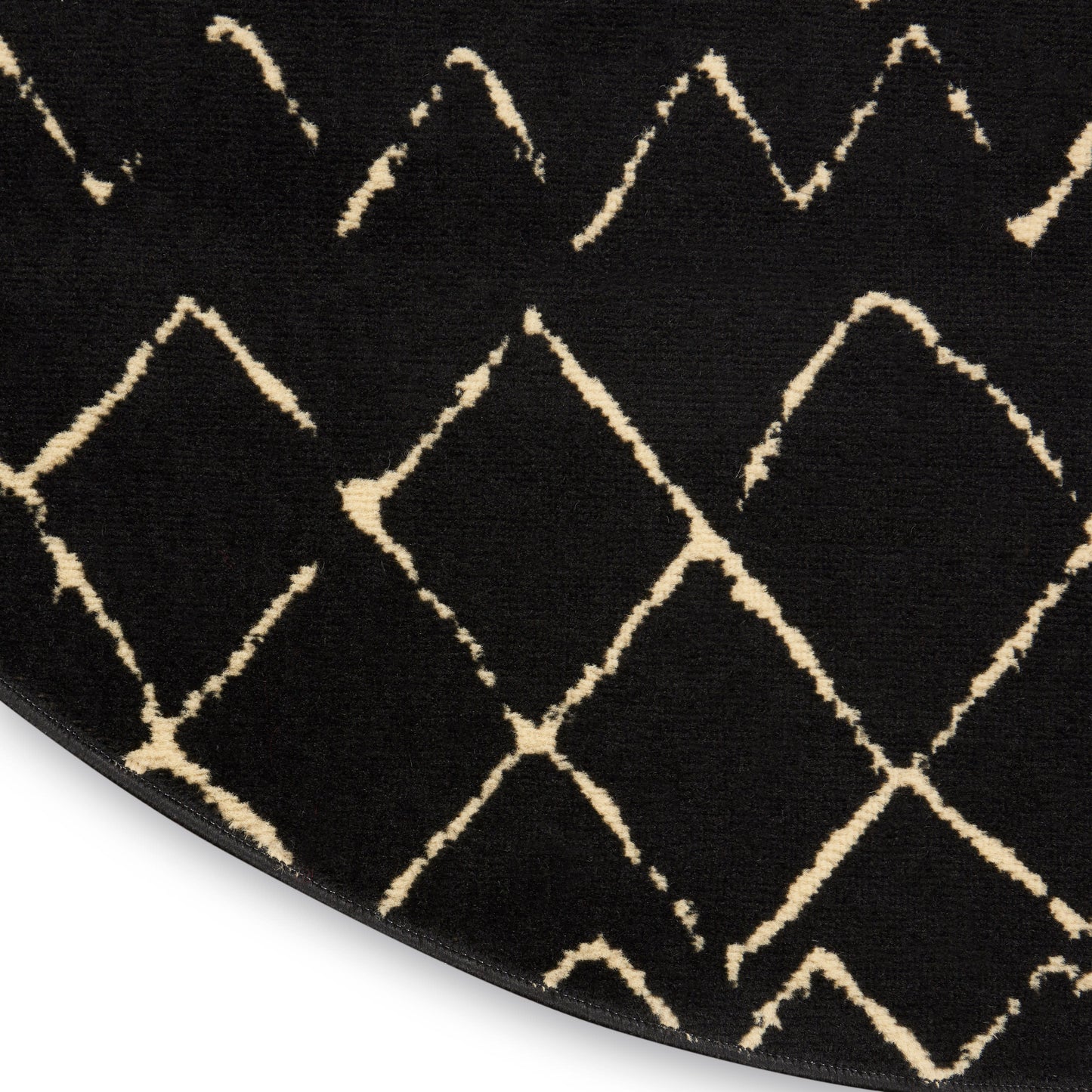 Round black rug with cream diamond lattice pattern, plush pile, modern geometric style.