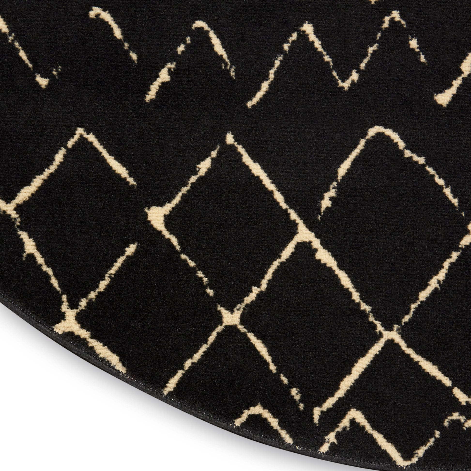 Round black rug with cream diamond lattice pattern, plush pile, modern geometric style.