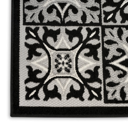Black & white patterned rug with a floral tile motif, textured loop pile, rectangular border, 3' x 4'.