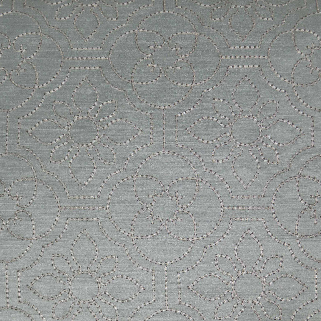 Light blue-gray fabric with white dotted embroidery forming circular floral medallions and geometric lattice.
