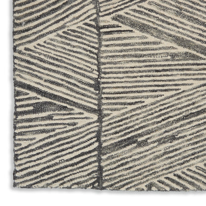 Textured cream rug with dark gray linear leaf pattern; boucle loop pile for a modern geometric look.
