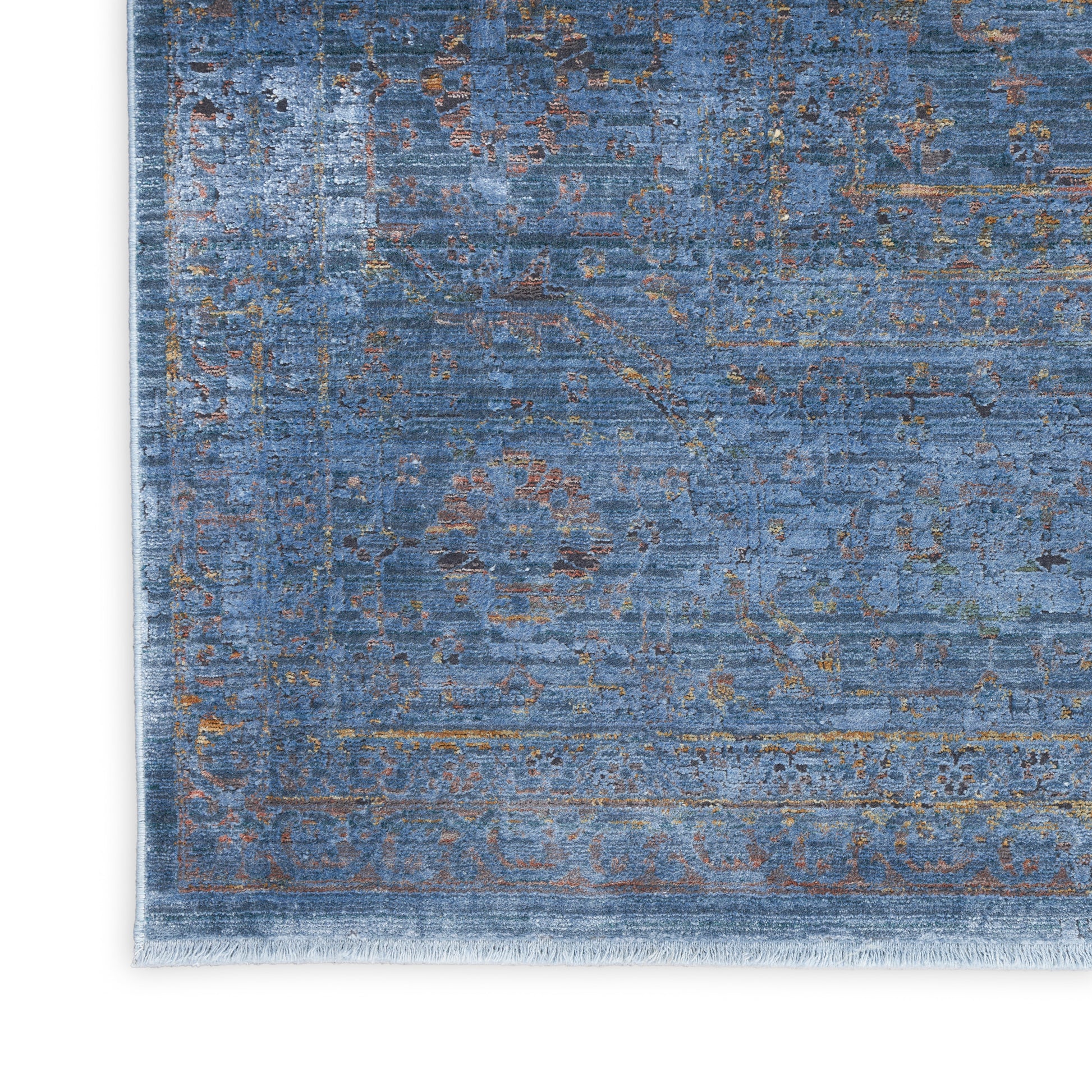 Blue vintage-style rug with faded floral pattern and light fringe.