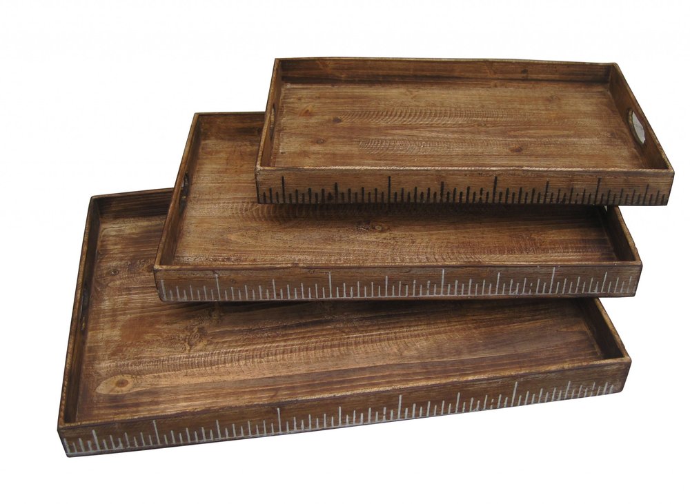 Three rustic dark-brown wooden serving trays in varying sizes stacked; edges feature white ruler-like markings.
