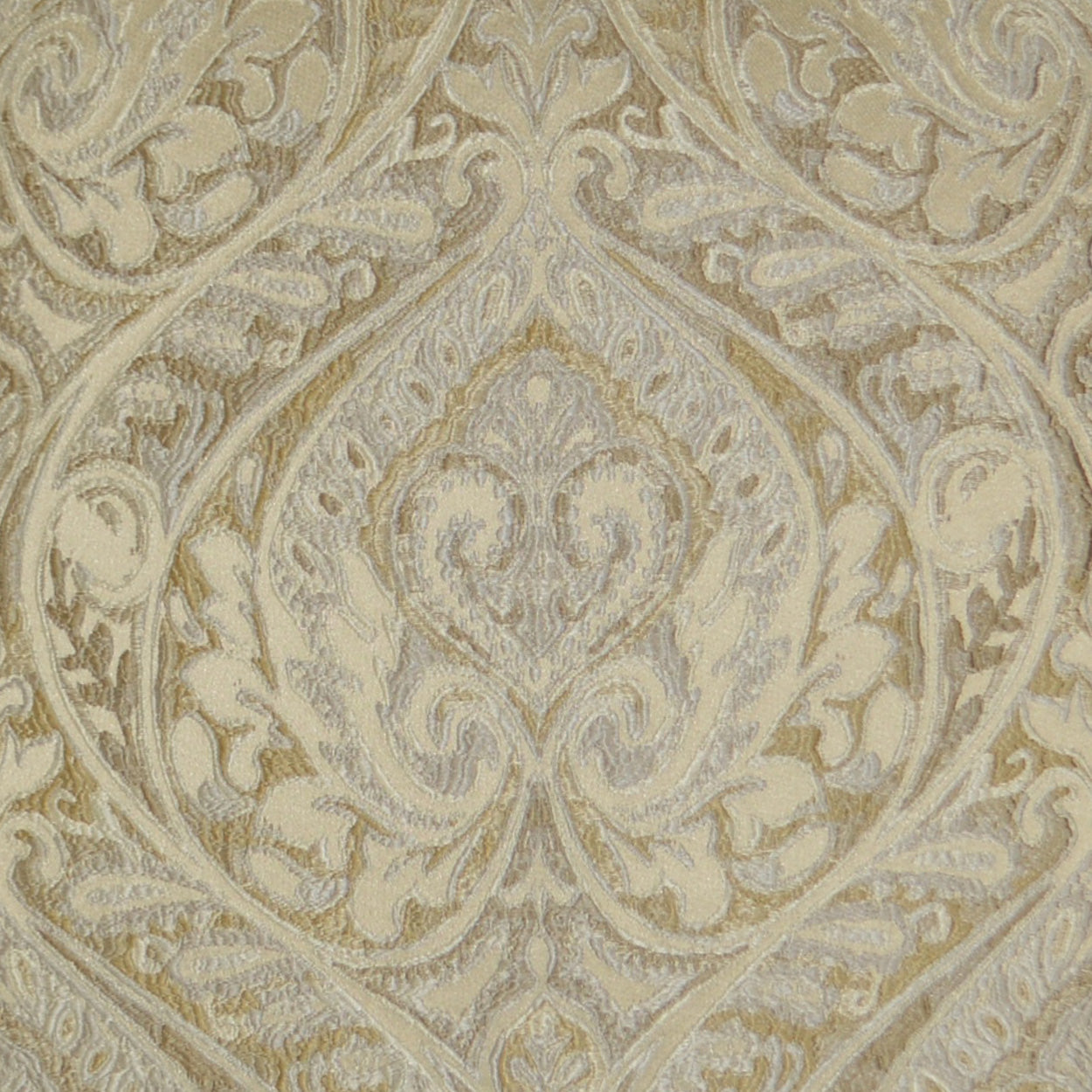 Beige-gold damask fabric with ornate scrolling floral motif; luxurious upholstery or drapery material.