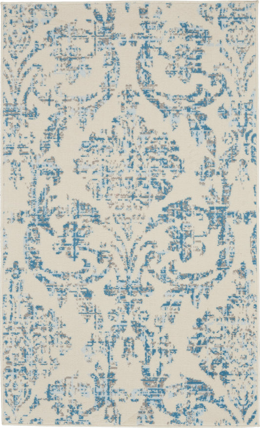 Rectangular cream rug with blue distressed damask pattern; vintage-inspired ornamental design.