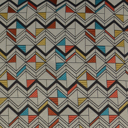 Geometric chevron fabric with black zigzags and turquoise, orange, yellow triangles on a beige background.