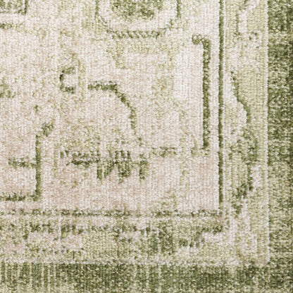 Close-up of beige rug with olive-green border and subtle floral pattern; plush textured pile.