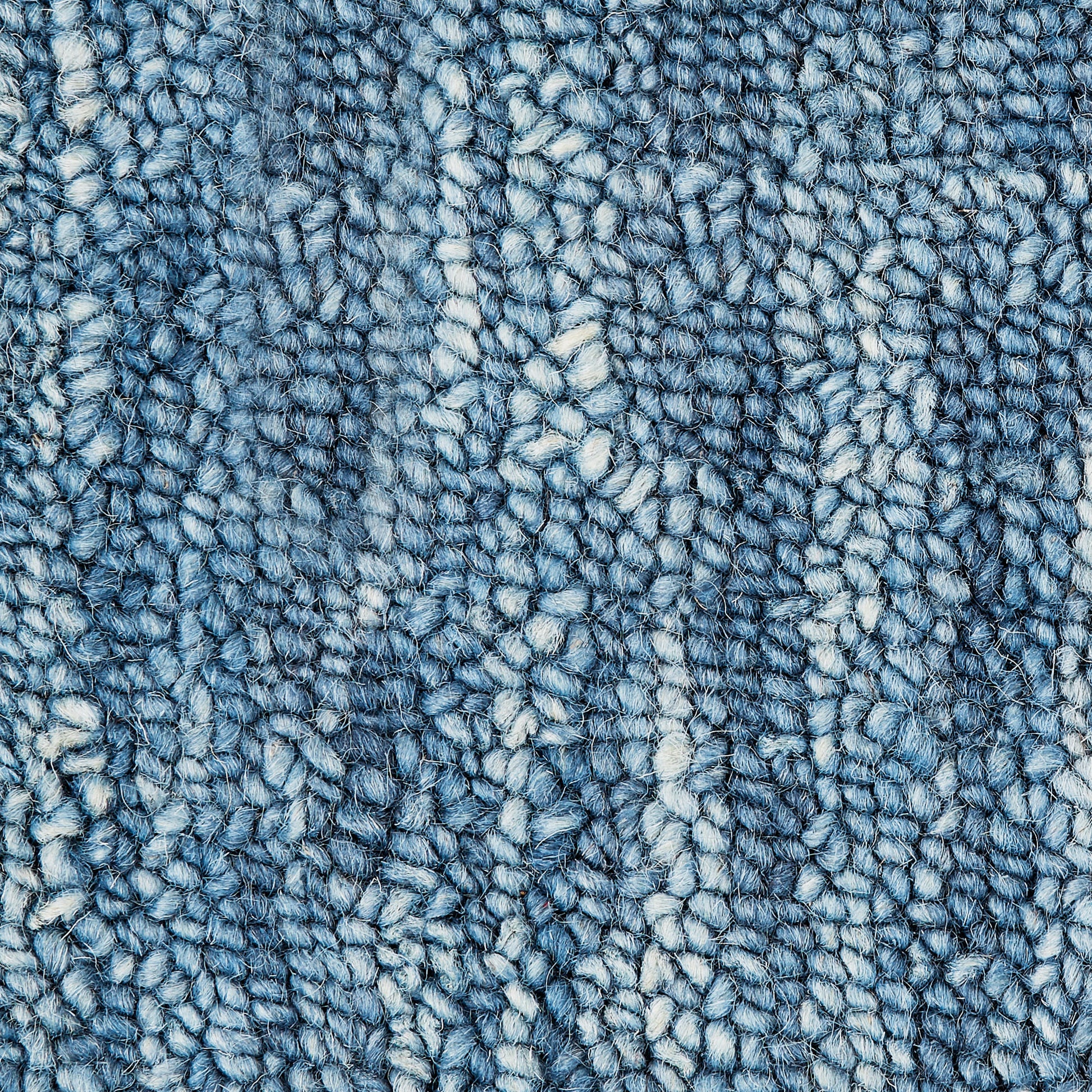 Blue loop-pile rug close-up with variegated light and dark blue yarns.
