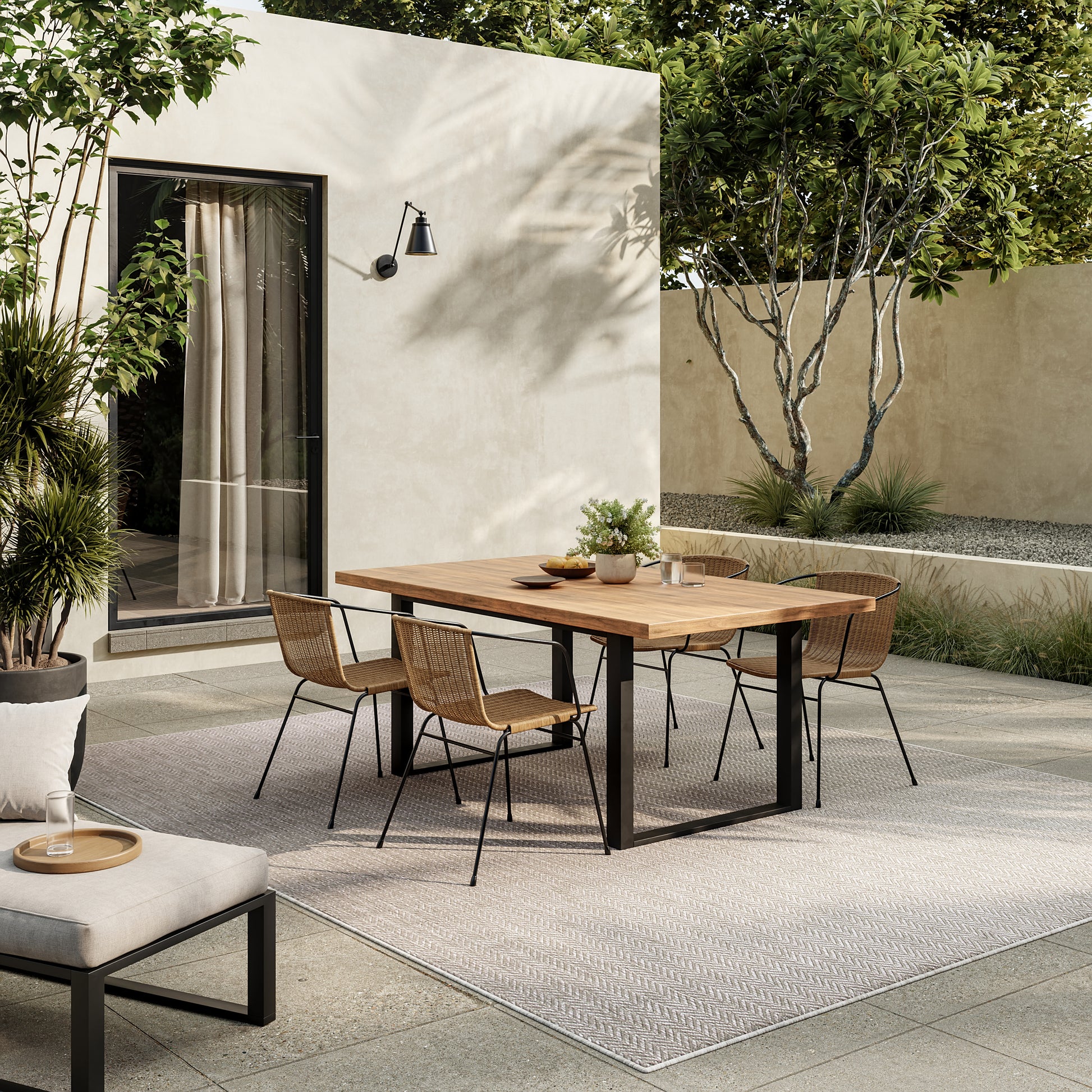 Modern outdoor rug: beige rectangular rug (10' x 14') laid on a patio with greenery.