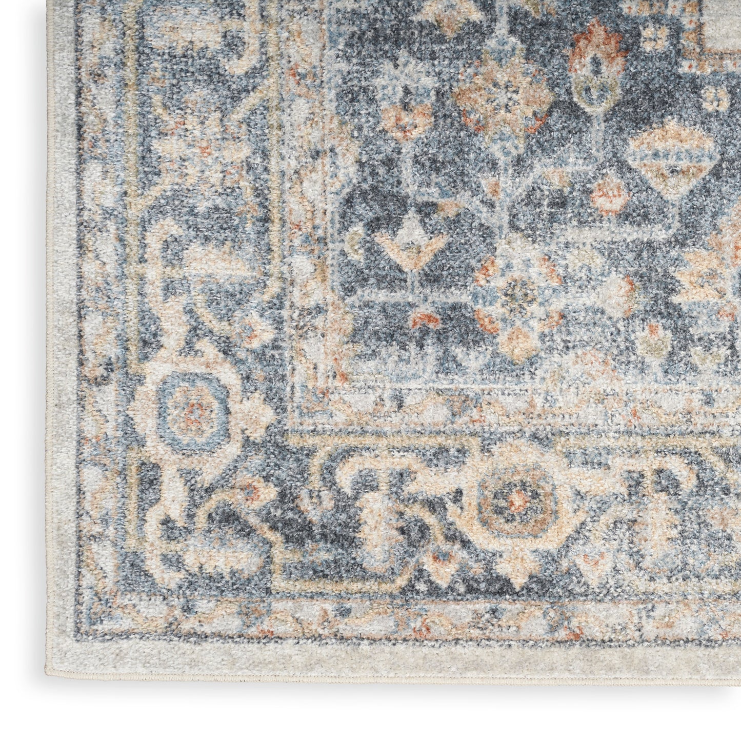 Rectangular area rug in blue, ivory and beige with distressed oriental floral border and central medallion.