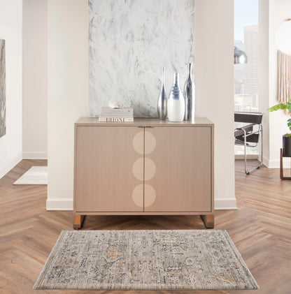 Light wood sideboard with three vertical circular inlays, metal legs; modern Scandinavian storage with vases and books.