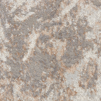 Close-up of a plush area rug with an abstract marbled pattern in beige, taupe and cream.