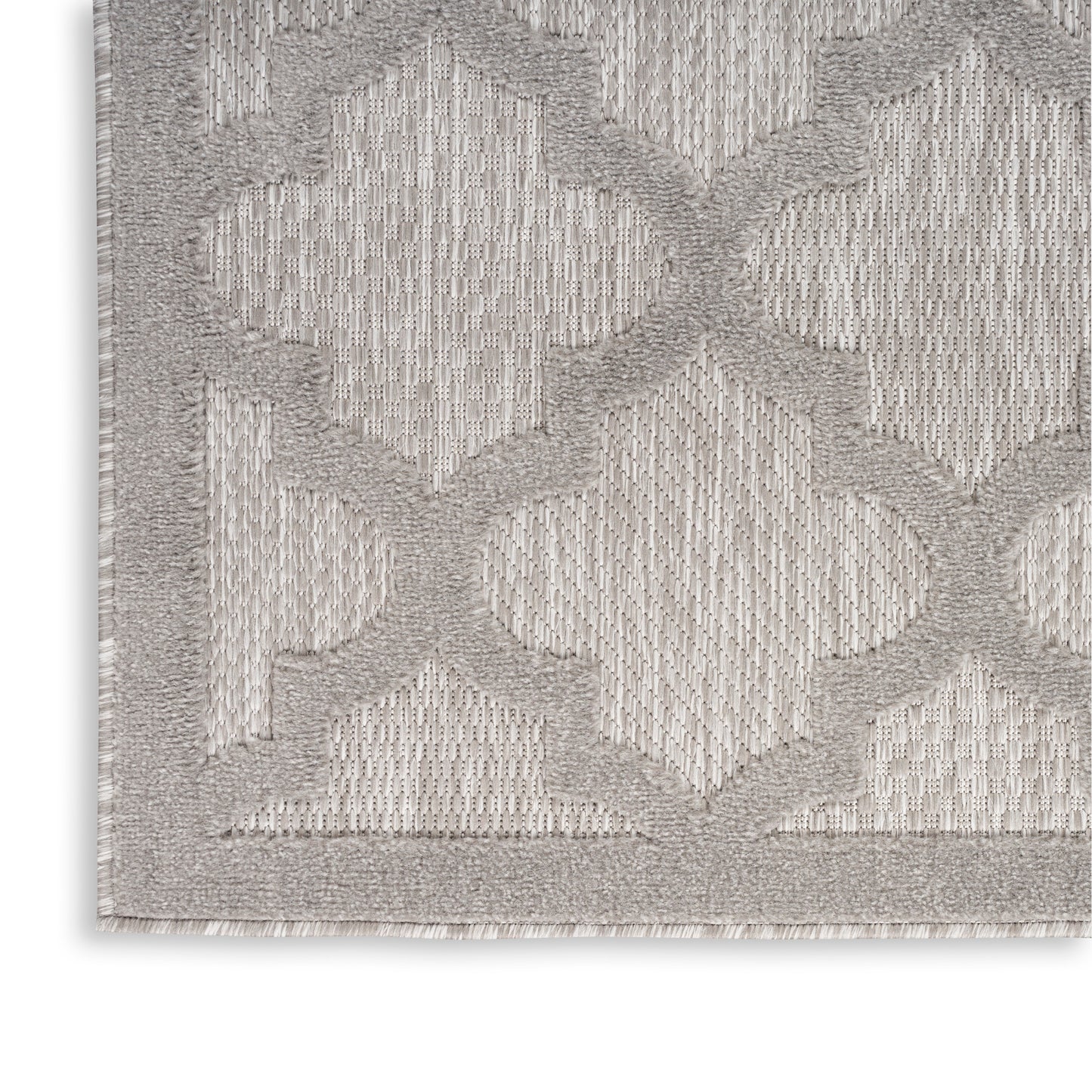 Light gray rug with a raised geometric diamond trellis pattern, soft woven texture and fringe along the edge.