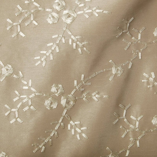 Beige satin fabric with cream embroidered twig-like branches forming a delicate floral pattern.