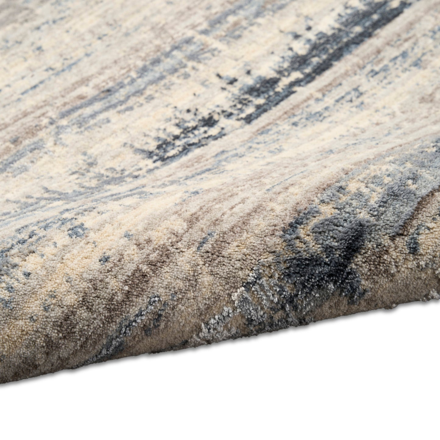 Close-up of a textured beige and blue abstract-pattern rug with dense, soft high-pile.
