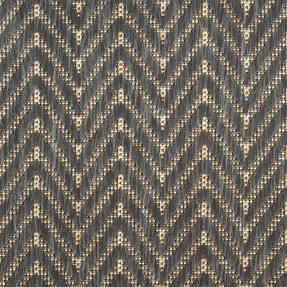 Dark gray chevron rug with beige dotted accents; textured zigzag pattern.