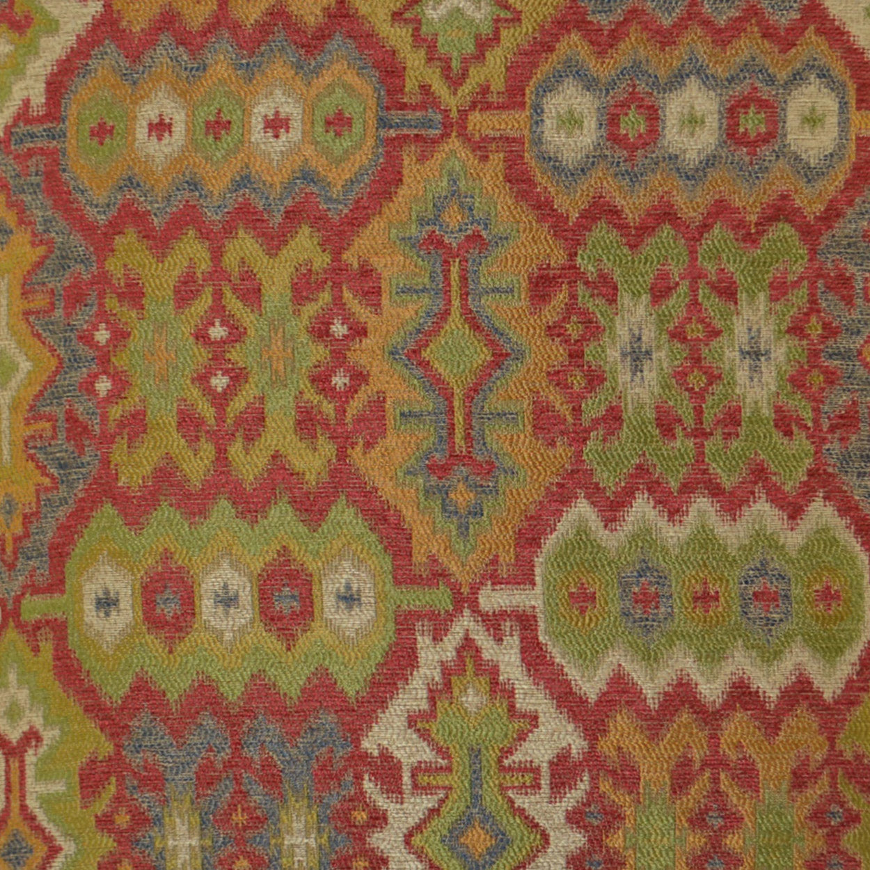 Vibrant kilim-inspired fabric with interlocking geometric motifs in pink, red, lime, yellow, blue and ivory.
