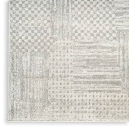 Neutral patchwork runner rug in light gray & ivory, with striped & dotted blocks & a soft textured weave, 8 ft long.