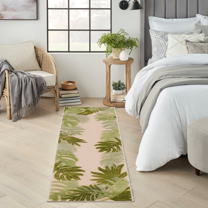 Rectangular tropical palm leaf outdoor runner rug in beige with green foliage.