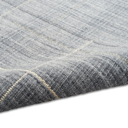 Blue-gray woven area rug with a subtle geometric pattern and light beige border.