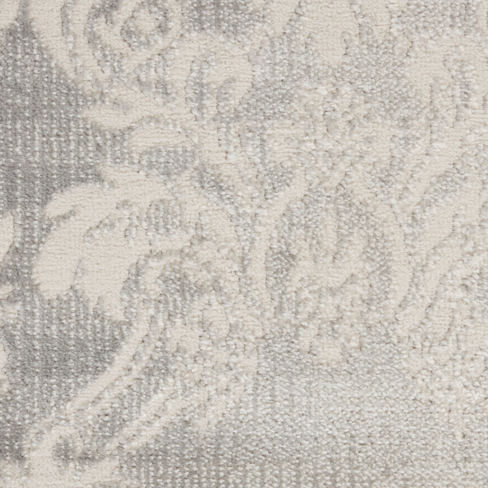 Close-up of pale gray damask woven fabric with ornate floral pattern and plush texture.