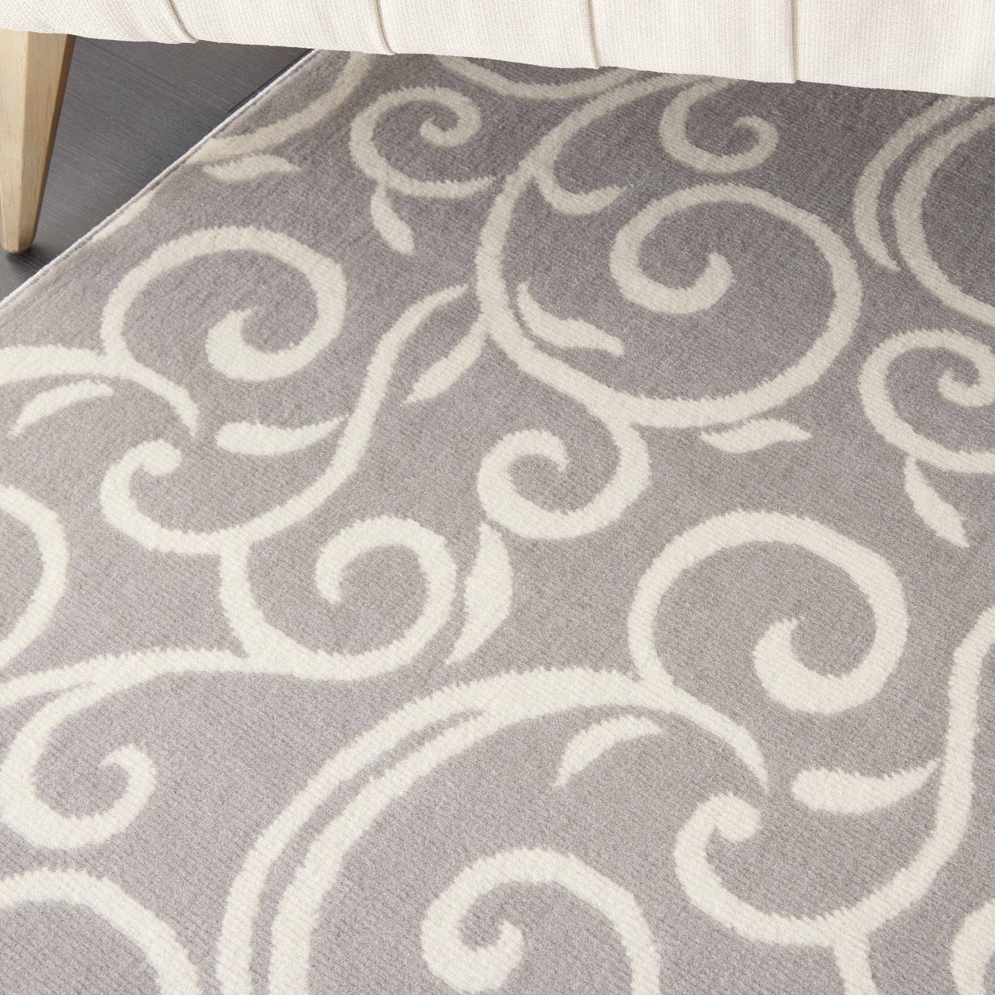 Grey rug with white swirling scroll pattern; plush pile, modern damask style for living room.